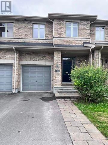 Ottawa townhouse for rent - A house with a black door and a garage door.