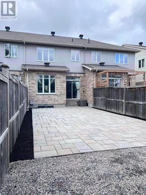 Ottawa townhouse for rent - A grey house with a stone pillar in front of it.