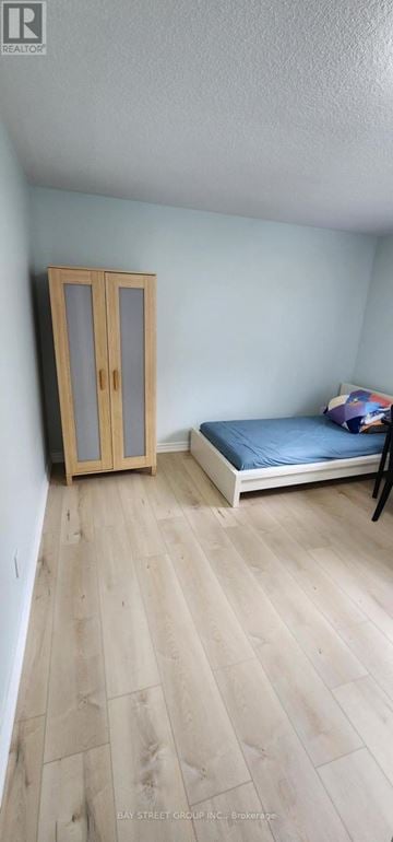 Toronto (Bayview Woods-Steeles) apartment for rent - A bedroom with a bed, wooden floor, and a wardrobe.