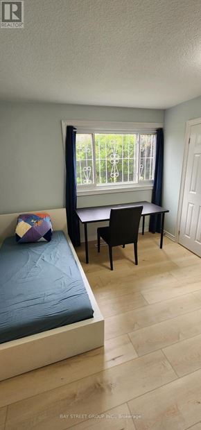 Toronto (Bayview Woods-Steeles) apartment for rent - A bedroom with a bed, chair, and window.