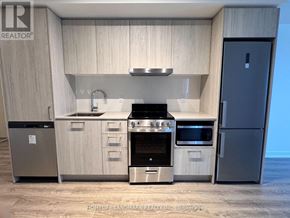 Vaughan (Vaughan Corporate Centre) condo for rent - A modern kitchen with a stainless steel refrigerator and a stove top oven.