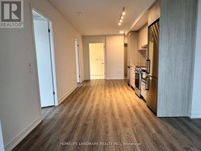 Vaughan (Vaughan Corporate Centre) condo for rent - A spacious kitchen with wooden flooring and a refrigerator on the right side.