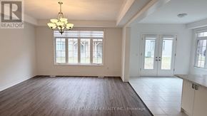 Springwater (Midhurst) apartment for rent - A large, empty room with a chandelier and a view of a street outside the window.