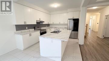 Springwater (Midhurst) apartment for rent - A kitchen with white cabinets and a black countertop is on the market.