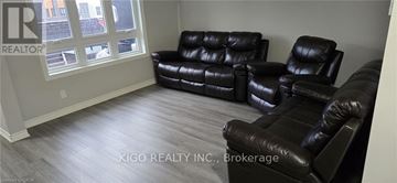 Kitchener townhouse for rent - A living room with black leather furniture and a window.