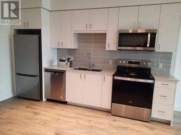 Cambridge condo for rent - A kitchen with a black fridge, stainless steel dishwasher, and oven.