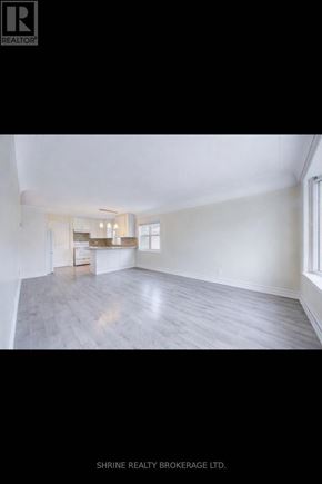 London East (East M) apartment for rent - A spacious room with a kitchen area in the background.