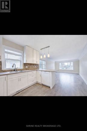 London East (East M) apartment for rent - A well-lit kitchen with wooden floors and white cabinets.