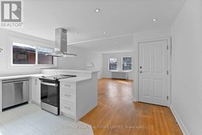 Toronto (Lawrence Park South) multi-family for rent - A modern kitchen with white appliances and wooden floors.