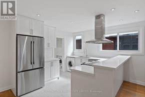 Toronto (Lawrence Park South) multi-family for rent - A modern kitchen with stainless steel appliances and white cabinetry.