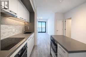 Toronto (Bayview Village) condo for rent - A modern kitchen with white cabinets and a stone backsplash.