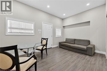 Hamilton apartment for rent - A living room with a grey couch, a glass table and two chairs.