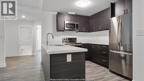 Windsor condo for rent - A modern kitchen with dark wood cabinets and stainless steel appliances.