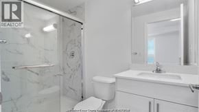 Windsor condo for rent - A white bathroom with a marble shower and toilet.