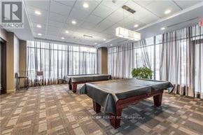 Toronto (Newtonbrook East) condo for rent - A spacious room with a massage table and a plant in the corner.
