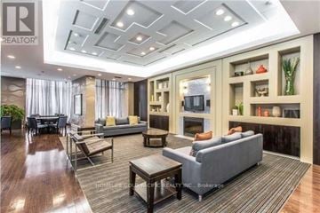 Toronto (Newtonbrook East) condo for rent - A well-lit, spacious living room with a grey sofa and wooden coffee table.