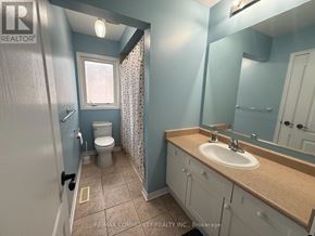 Ajax (Northeast Ajax) apartment for rent - A bathroom with a toilet, sink, and mirror.