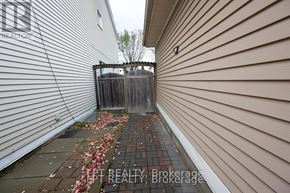 Ottawa apartment for rent - A narrow alley with a wooden fence and a brick path.