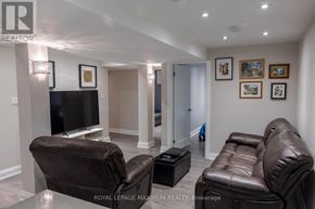 Vaughan (Vellore Village) apartment for rent - A living room with a brown leather couch and a black television.