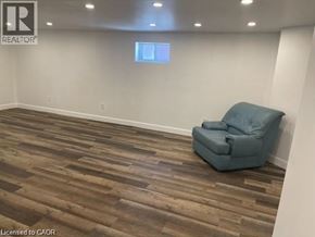 Hamilton apartment for rent - A room with a blue chair and wooden flooring.