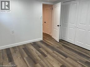 Hamilton apartment for rent - A room with a wooden floor and white walls, with a doorway leading to another room.