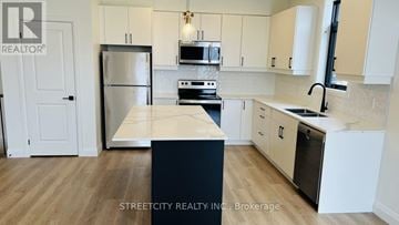 London South (South V) townhouse for rent - A kitchen with a refrigerator, microwave, oven, and sink.