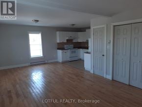 Edwardsburgh/Cardinal apartment for rent - A room with wooden floors and white walls.