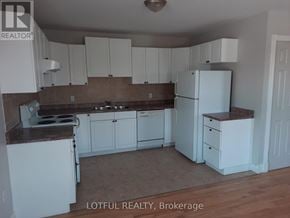 Edwardsburgh/Cardinal apartment for rent - A kitchen with white cabinets and a white refrigerator.