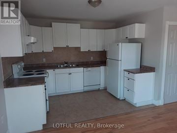 Edwardsburgh/Cardinal apartment for rent - A kitchen with white cabinets and a white refrigerator.
