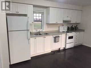 Markham (Cornell) apartment for rent - A kitchen with white appliances and cabinets.