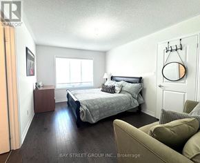Innisfil (Lefroy) apartment for rent - A bedroom with a bed, couch, and lamp.
