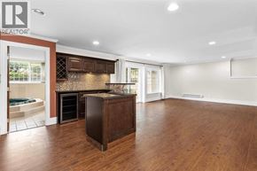 Vancouver apartment for rent - A large, empty room with a wooden floor and a kitchen area with a refrigerator, oven, and microwave.