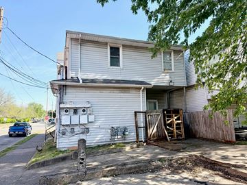 Louisville apartment for rent - A house with a white exterior and a garage door open.
