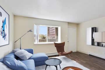 Englewood apartment for rent - A living room with a blue couch and a brown chair.