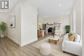 Cobourg apartment for rent - A well-lit, spacious living room with a white sofa, wooden coffee table, and a large painting on the wall.