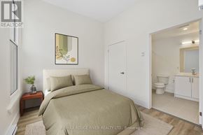 Cobourg apartment for rent - A bedroom with a bed, nightstand, and a framed picture on the wall.