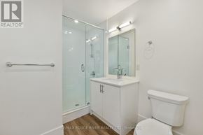 Cobourg apartment for rent - A white bathroom with a glass shower door and a white toilet.