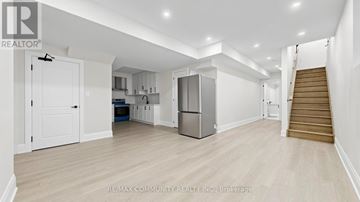 Pickering apartment for rent - A spacious kitchen with white cabinets and a refrigerator.