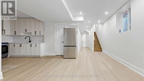 Pickering apartment for rent - A spacious kitchen with white cabinets and a wooden floor.