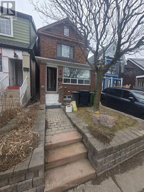 Toronto (Weston-Pellam Park) apartment for rent - A house with a brick wall and a tree in front.