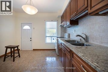 Toronto (Dovercourt-Wallace Emerson-Junction) townhouse for rent - A kitchen with brown cabinets and a sink.