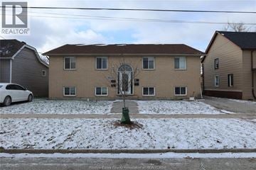 Windsor apartment for rent - A white car is parked in front of a house with a brown roof.
