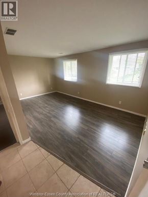 Windsor apartment for rent - A room with wooden flooring and two windows.