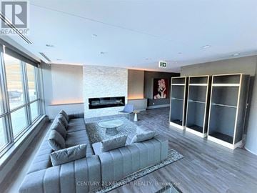 Toronto (Annex) condo for rent - A modern living room with a grey sofa and a glass table.