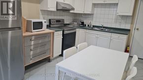 Vaughan (Islington Woods) apartment for rent - A kitchen with a white table and white cabinets.
