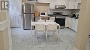 Vaughan (Islington Woods) apartment for rent - A kitchen with a table and chairs in front of a refrigerator.