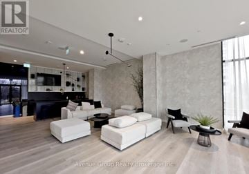 Mississauga (Cooksville) condo for rent - A living room with a black sofa and white couches.