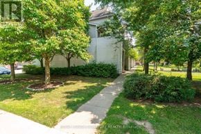 Waterloo townhouse for rent - A white house with a tree in front of it.