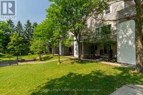 Waterloo townhouse for rent - A grassy area in front of a building with a sign that says Royal LePage Signature Realty, Brokerage.