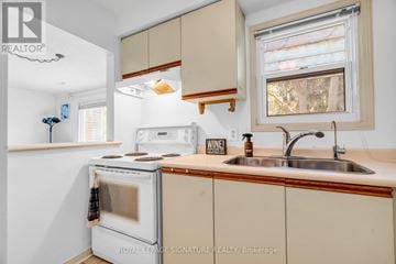 Waterloo townhouse for rent - A kitchen with a white oven and beige cabinets.